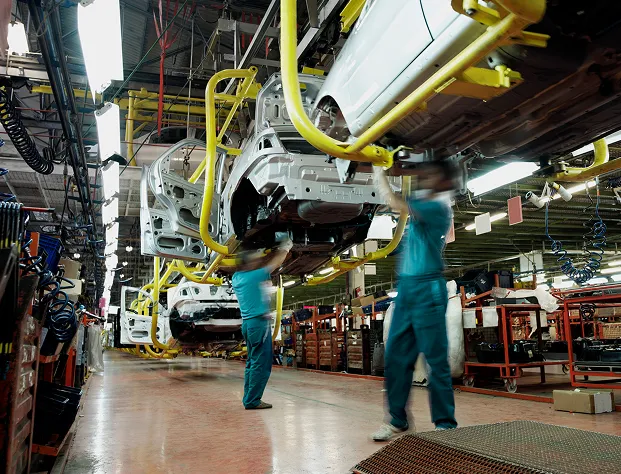 Two people working underneath a car