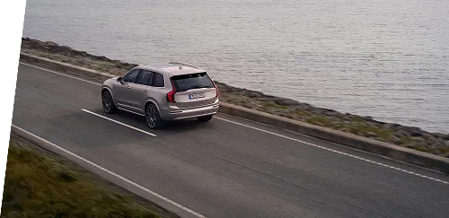 Minivan driving next to water